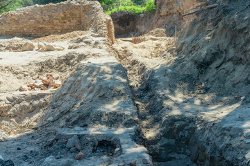 Historical Ruins Unearthed Archaeology Site. Urban Archaeological Excavation Showing Old Brick Wall...