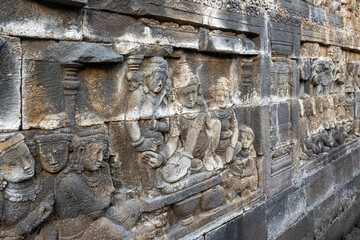 Stone reliefs depict ancient figures in intricate detail on a historic temple wall.