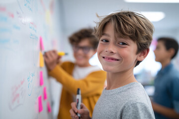 Young boy smiling, brainstorming with classmates. Education concept. Collaborative learning, problem solving, ideas, teamwork. Bright classroom scene.