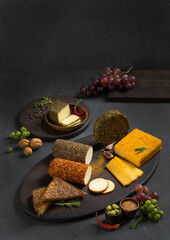 Several types of cottage cheese and cream cheese with spices among vegetables, herbs and fruits