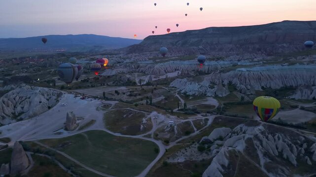 Drone footage of colorful balloons over Cappadocia landscape, Turkey