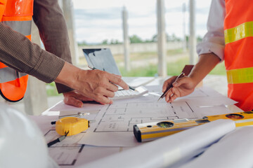 Construction contractor, checking and recording construction details using tape measure and not...