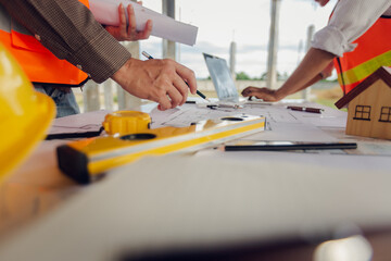 Construction contractor, checking and recording construction details using tape measure and not...