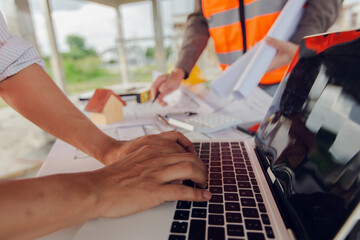 Obraz premium Construction contractor, checking and recording construction details using tape measure and not measuring water level, wearing yellow construction uniform, house construction contractor, concept
