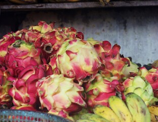 Pile of Dragon Fruit and Bananas at Market Stall