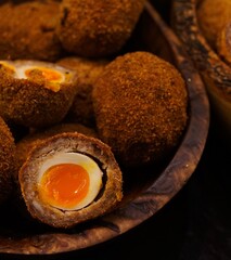 Beautiful scotch eggs in wooden bowl, crispy outside, soft and tender inside