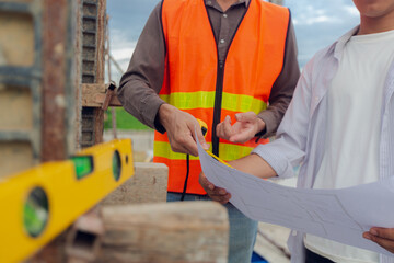 Construction contractor, checking and recording construction details using tape measure and not measuring water level, wearing yellow construction uniform, house construction contractor, concept