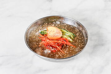 Cold Buckwheat Noodles (Korean cool noodles) decorated on thet marble table.