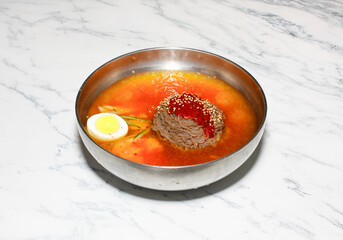 Cold Buckwheat Noodles (Korean cool noodles) decorated on thet marble table.