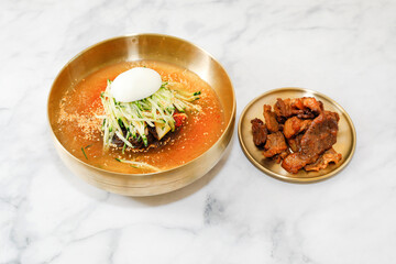 Cold Buckwheat Noodles (Korean cool noodles) decorated on thet marble table.