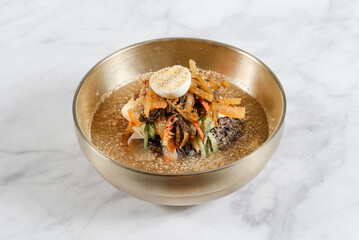 Cold Buckwheat Noodles (Korean cool noodles) decorated on thet marble table.