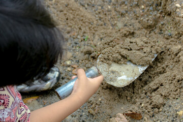 Child Digging in Dirt with Shovel Outdoors Playing