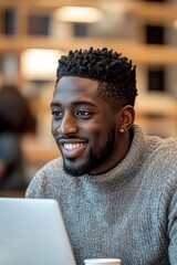 Smiling young African American man using a laptop