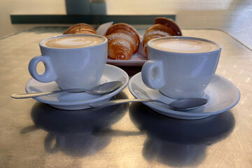 cup of cappuccino and croissants