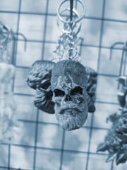 Objects keychains in form of skull of man, models of toys printed on 3D printer from molten plastic...