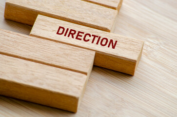 Direction word shown on separated wooden blocks on a table, representing focus, vision, and the...