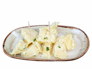 Delicious homemade potato salad served on a ceramic platter with fresh herbs and toothpicks