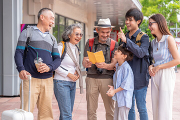 three generations family as the tourists having backpacks and suitcase standing at tourist...