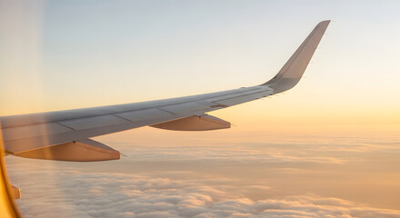 Fototapeta premium Airplane Wing in Sunset Sky with Clouds During Flight
