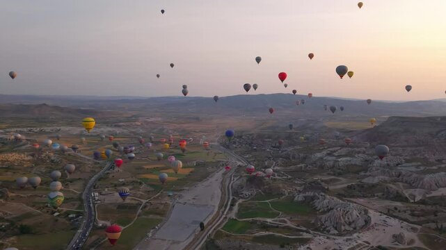 Drone footage of colorful balloons over Cappadocia landscape, Turkey