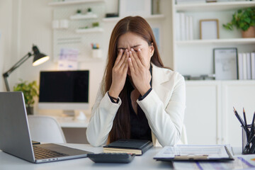Young businesswoman experiencing anxiety and fatigue during work.