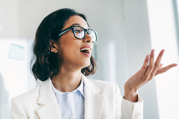 Confident businesswoman speaking in an office environment, demonstrating leadership and creativity...