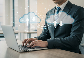 Executive connected to the cloud, performing data uploads and downloads on a laptop in a workplace.
