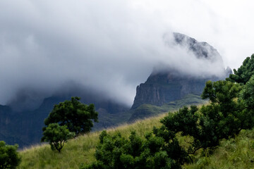 Dramatic view of rain clouds covering and shrouding the high mountain peak of Sentinel peak in the...