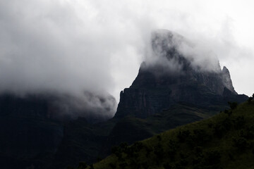Ominous, dark view of Sentinel Peak in the Drakensberg mountains shrouded by the clouds of a...