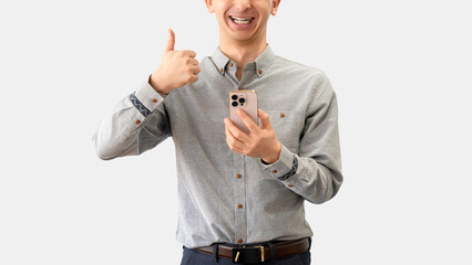 スマートフォンを持っていいね！のポーズをする男性