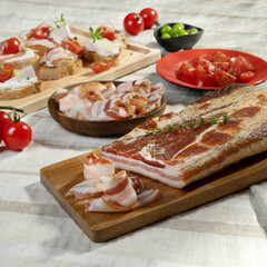 Meat delicacies and smoked meats sliced ​​on a light table