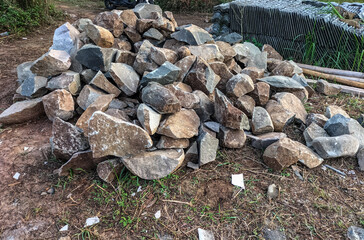 Selective focus. A pile of mountain rock fragments lying on the ground for the foundation of a...