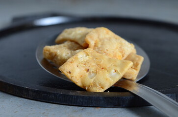 Crispy Indian snack ajwain mathri – deep-fried flaky crackers made with carom seeds and flour, served as tea-time snack or festive treat – traditional North Indian savory
