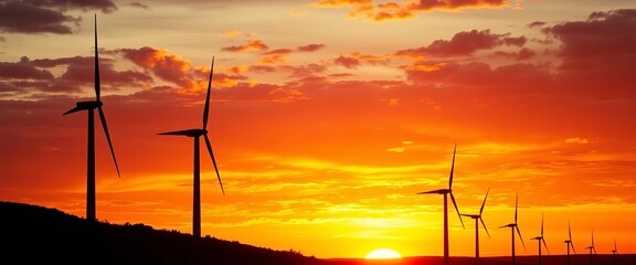 Obraz premium Silhouetted wind turbines against a fiery Spanish autumn sunset, Spanish countryside, wind turbine