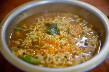 ramyeon: korean spicy instant noodles soup cooking in hot pot with chopsticks
