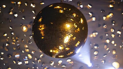 Rotating disco ball illuminates vibrant dance floor with golden reflections - Powered by Adobe