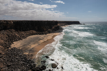 Vista panorámica de Piedra Playa con surfistas en el mar, en El Cotillo, Fuerteventura