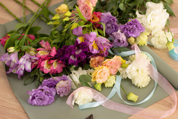 The process of assembling a bouquet of flowers in a flower shop. Neutral colors