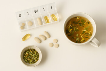 Flat Lay with Home Medicine Elements: Herbal Tea, Supplements, and Weekly Pill Organizer