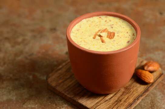 Refreshing Indian drink badam milk &ndash; chilled almond-flavored milk infused with cardamom and saffron, garnished with sliced nuts &ndash; traditional festive beverage