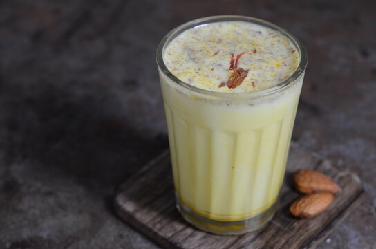 Refreshing Indian drink badam milk &ndash; chilled almond-flavored milk infused with cardamom and saffron, garnished with sliced nuts &ndash; traditional festive beverage