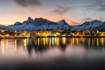 Husøy auf der Insel Senja in Norwegen im Winter zur goldenen Stunde, beleuchtete Inselsiedlung...
