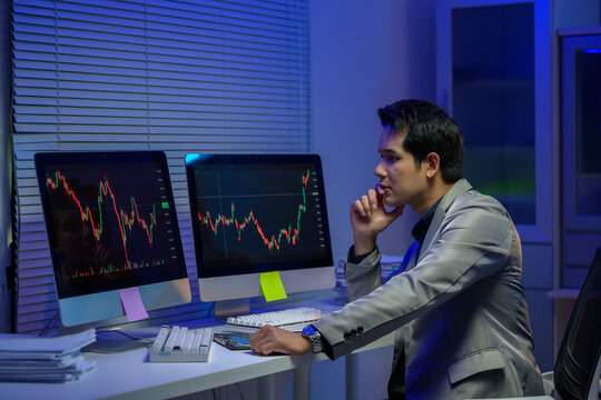 Stockbroker analyzing cryptocurrency and financial market data at night