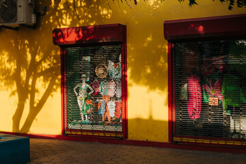 Colorful storefront with enticing displays in late afternoon sunlight on a vibrant wall