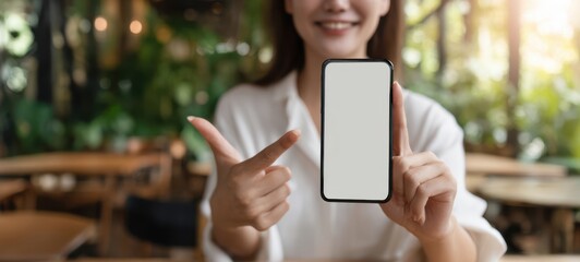 The woman showcasing a smartphone in a vibrant café setting.
