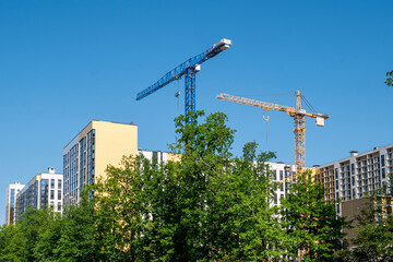 Voronezh, Russia, May 24, 2025: Construction of new high-rise buildings construction cranes in...