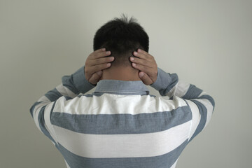 An asian unhappy and annoyed business man is suffering headache and stresses, closing his ears with...
