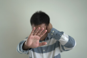 An asian unhappy and annoyed business man is suffering headache and stresses, closing his ears with...