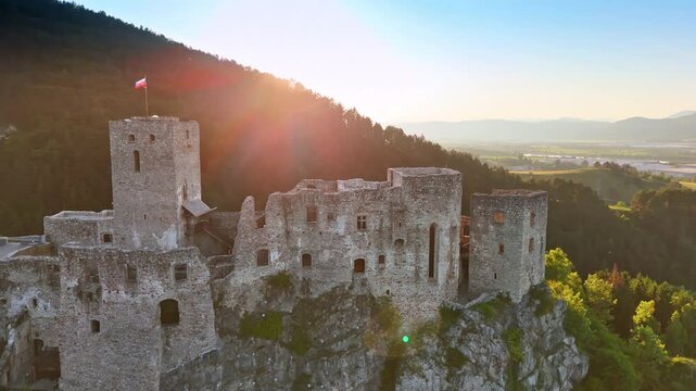 Slovak flag waving on the top of the castle on the mountain top. Beautiful countryside at the river bank at backdrop. Aerial view.