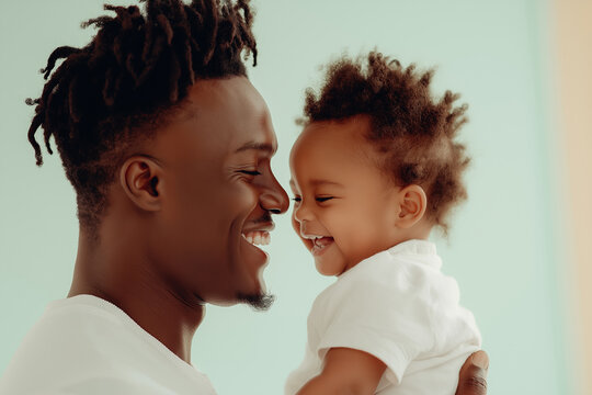 Smiling father holding happy baby in bright room, close view
